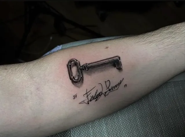 Llave antigua realista con una firma y unos números, en el antebrazo