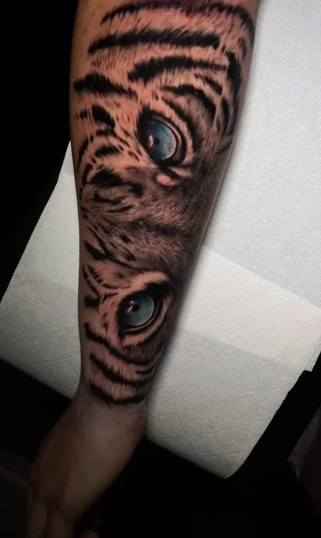Mirada de tigre en microrrealismo tatuada en el antebrazo