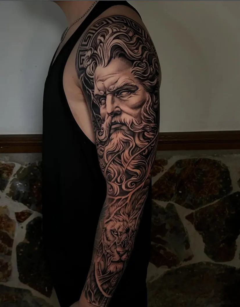 Manga completa con el rostro de Zeus y un león, realismo en negro y gris